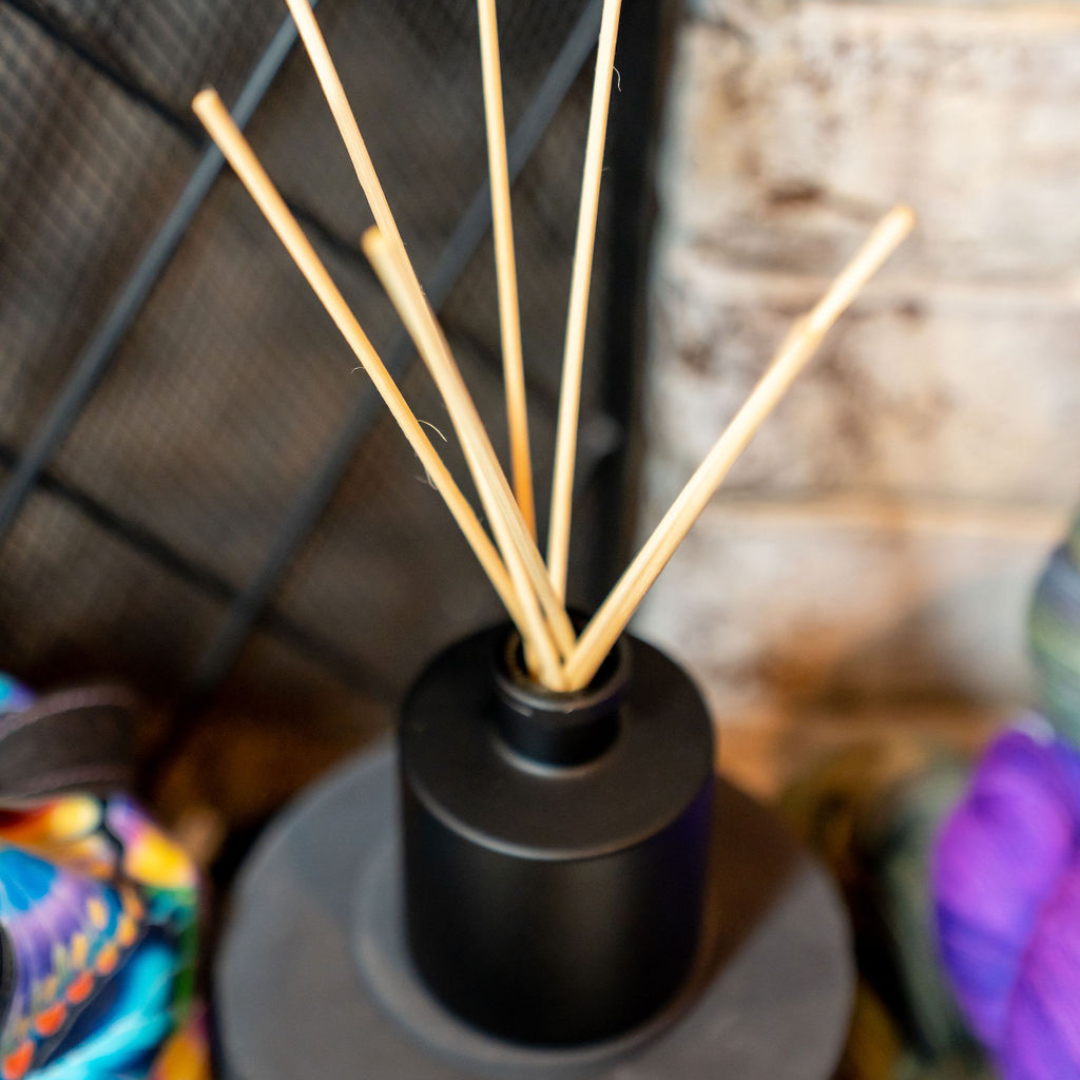 black diffuser in front of a fire place with no fire, and 6 standard reeds